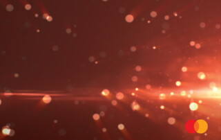 Brighterion blog cover: orange light bursts with Mastercard logo